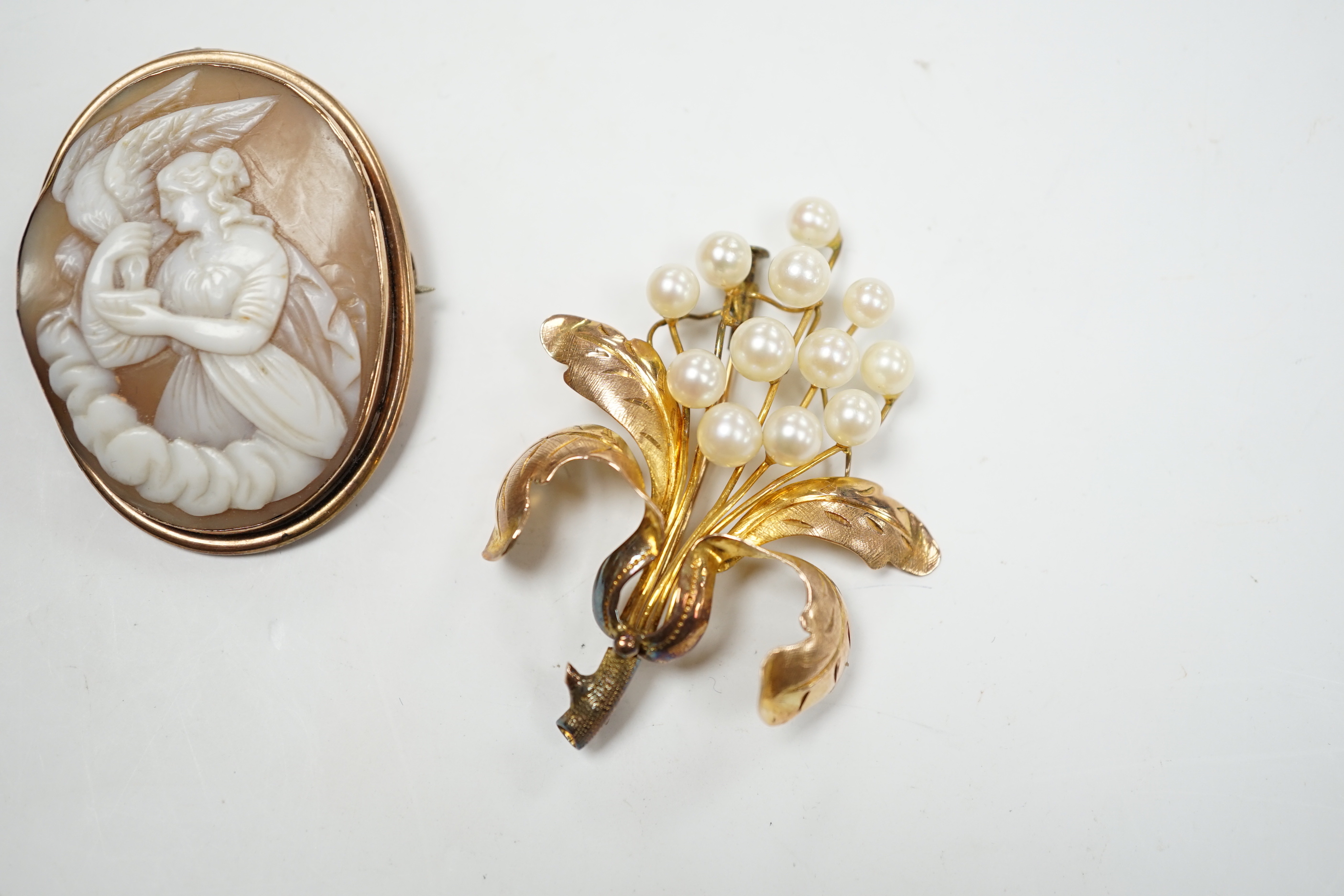 A 14K yellow metal and cultured pearl cluster set floral brooch, 52mm, gross weight 7 grams, together with a yellow metal mounted carved cameo shell brooch.